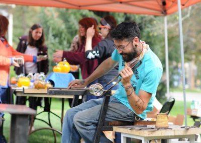 Instructor works glass at outdoor festival